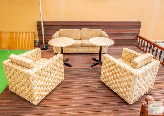 Imagen de nuestra terraza de madera equipada con nuestros sofisticados sillones de mimbre, perfectos para personalizar tu evento