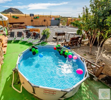 Vista aérea parcial de la finca decorada para un cumpleaños, con la piscina adornada con globos