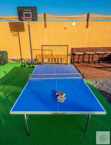 Zona de juego con mesa de ping pong, canasta de baloncesto y portería de fútbol