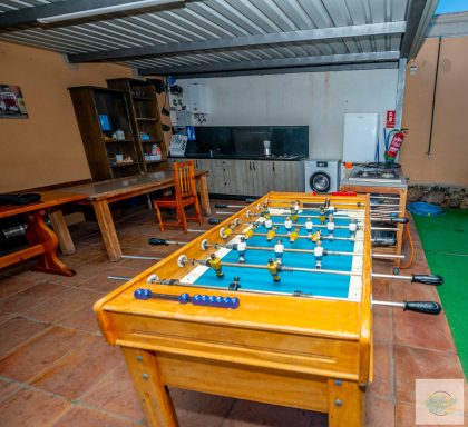 Imagen de la cocina exterior con terraza y un futbolín